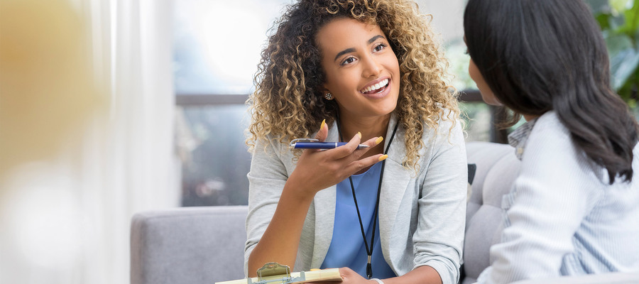 Counsellor talking to a client while holding a clipboard